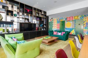 een woonkamer met groene meubels en een televisie bij citizenM Glasgow in Glasgow