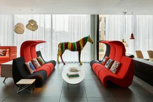 een woonkamer met twee rode banken en een paardenbeeld bij citizenM Glasgow in Glasgow
