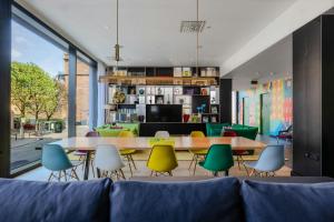 een woonkamer met een bank en tafels en stoelen bij citizenM Glasgow in Glasgow