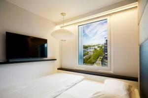 a bedroom with a window with a bed and a tv at citizenM Paris Gare de Lyon in Paris