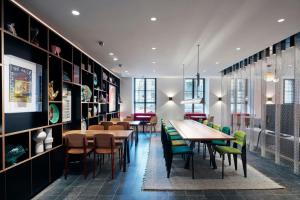 a restaurant with tables and chairs in a room at citizenM Geneva in Geneva