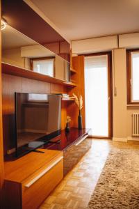un salon avec une grande télévision à écran plat dans l'établissement 203 Aosta Apartment, à Aoste