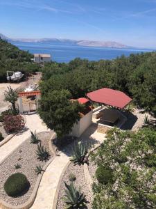 a building with a red roof with a view of the water at Apartments in Sveti Juraj 27785 in Burnjak