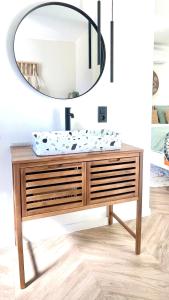 a bathroom vanity with a round mirror above it at Chambre d Amis in Lokeren