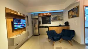 a kitchen with two blue chairs and a refrigerator at 407-3 · Duplex Sossego in Anápolis