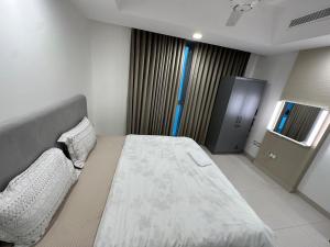 a bedroom with a large bed and a window at Central Bliss Apartment in Muscat