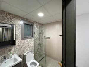 a bathroom with a toilet and a sink and a shower at Central Bliss Apartment in Muscat +9 photos