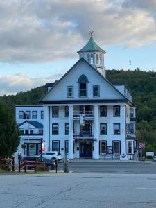 un grand bâtiment blanc avec une tour au sommet dans l'établissement Thayers Inn, à Littleton