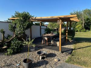 een houten pergola met een tafel in een tuin bij Ferienwohnung am Koppenstein in Calden