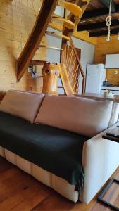 a leather couch in a room with a staircase at Chalé cruzeiro do sul, hidromassagem, 2 min Thermas Machadinho-RS #1 in Machadinho