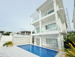 Un edificio blanco con una piscina enfrente. en Chateau Du Soleil, en San Vicente
