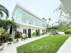 una gran casa blanca con césped delante en Chateau Du Soleil, en San Vicente