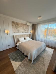 a bedroom with a large bed and a large window at Luxury Oasis in the Heart of the City in Druskininkai