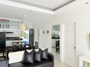 Una sala de estar con un sofá negro y un comedor. en Chateau Du Soleil, en San Vicente