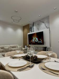 a dining room with a table with plates and wine glasses at Arjola Cozy Stay in Korçë