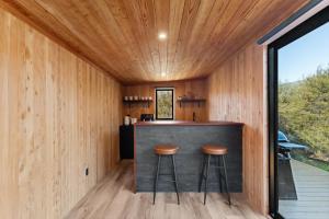 a kitchen with a bar in a wooden house at Luxury Container and Cabin with Outdoor Bath in Wanaka