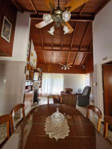 ein Esszimmer mit einem Tisch und einem Deckenventilator in der Unterkunft Casa Castelli in Mar de Ajó