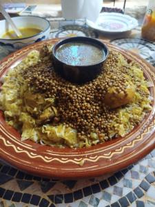 a plate of food with lentils and a bowl of sauce at Maison diyafa in Guelmim