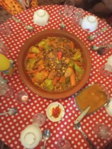 a table with a bowl of food on a red and white table cloth at Maison diyafa in Guelmim