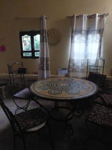 a room with a table and chairs and a window at Maison diyafa in Guelmim