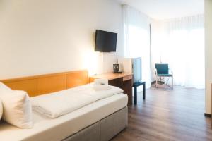 a bedroom with a bed and a desk with a television at The Business Loft in Wolfsburg