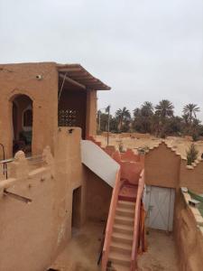 a building with a staircase in front of it at Maison diyafa in Guelmim +3 photos