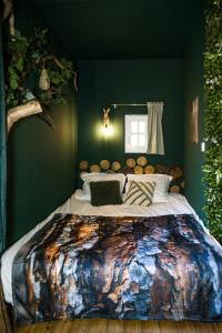 1 dormitorio con 1 cama grande en una pared verde en Le Sous-Bois, une parenthèse nature, en Bergerac