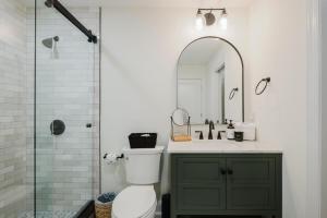 a bathroom with a toilet and a sink and a mirror at Lowcountry Landing! 3-story Townhouse in Old Town's Promenade in Bluffton