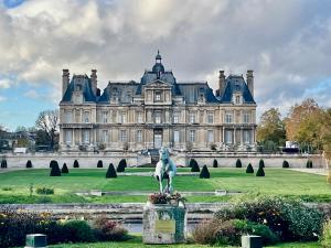 a large castle with a statue in front of it at Neuf et lumineux 2min Gare - 20min Paris in Maisons-Laffitte
