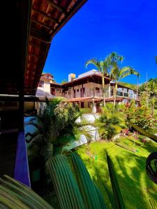 ein Haus mit Palmen vor einem Garten in der Unterkunft Pousada Dona Maria in Paraty + 12 Fotos