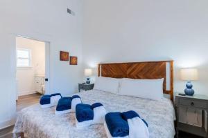 a bedroom with a large bed with blue pillows on it at Charming Old Town Loft, nestled in the Heart of Historic Bluffton, SC in Bluffton