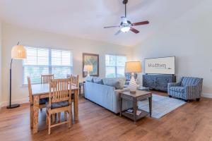 un salon avec un canapé bleu et une table dans l'établissement Calypso Cottage in Old Town Bluffton in the Heart of Historic Old Town, à Bluffton