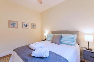 une chambre avec un grand lit blanc avec des serviettes dessus dans l'établissement Calypso Cottage in Old Town Bluffton in the Heart of Historic Old Town, à Bluffton 27 autres photos