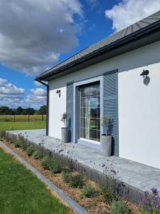 RadomierzDom Radomieszka z widokiem na Rudawy i Śnieżkę的白色的房子,有窗户和植物