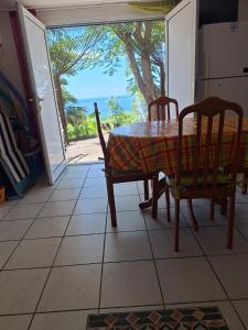 a table and chairs in a kitchen with a view of the ocean at Gite DANGIEN in Vieux-Habitants