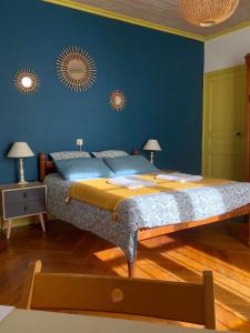 a bedroom with a large bed with a blue wall at A l'ombre du Fort in Fuilla