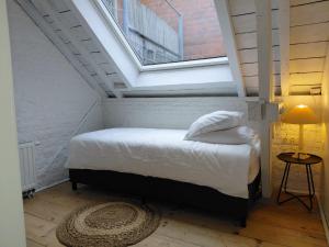 - une chambre mansardée avec une fenêtre dans l'établissement Logies De Lelie - Antwerpen Zuid, à Anvers