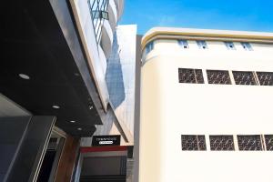 a white building with two windows on the side of it at Townhouse Hill Cart Road Siliguri in Siliguri