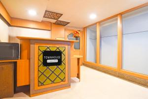 a room with a tv and a front door with a window at Townhouse Hill Cart Road Siliguri in Siliguri