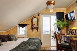 een slaapkamer met een bed, een bureau en een raam bij Strandflickornas Havshotell Lysekil in Lysekil