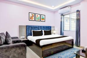 a bedroom with a large bed and a couch at Collection O SF Road Siliguri Formerly Jyoti Hotel in Siliguri +46 photos