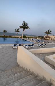 アズ・シーファーにあるVilla La Mer Sifahの海のそばのヤシの木と椅子付きのプール