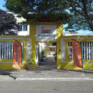 a yellow building with signs in front of it at Nova Pousada do Canal in Cabo Frio