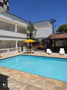 a swimming pool in front of a building at Nova Pousada do Canal in Cabo Frio