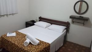 a bedroom with a bed with two towels on it at Nova Pousada do Canal in Cabo Frio +6 photos