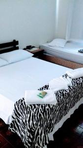 a hotel room with two beds with towels on the bed at Nova Pousada do Canal in Cabo Frio