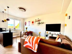 a living room with a couch and a kitchen at New flat close to center in Komárov