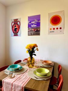 a dining room table with plates and flowers on it at New flat close to center in Komárov +28 photos