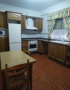 une cuisine avec une table et un réfrigérateur blanc dans l'établissement Toscana Valenciana 2, à Fontanares