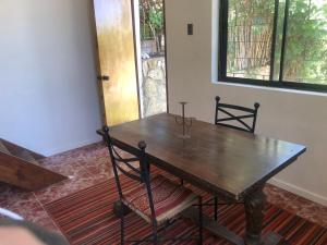 a wooden table and chair in a room with a window at Chalet Bordemar in Concón +11 photos